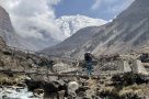 Crossing a suspension bridge with Tilicho Peak behind